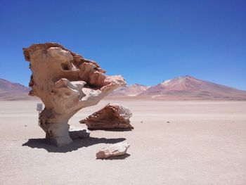 Scenic view of desert against clear blue sky