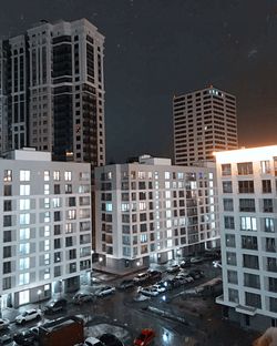 Modern buildings in city against sky at night