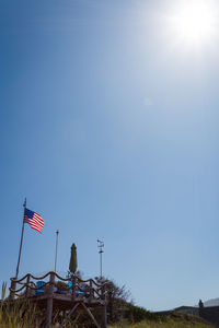 Low angle view of flag against clear blue sky