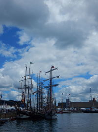 Sailboats moored at harbor