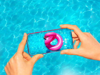 Cropped hand of woman holding swimming in pool