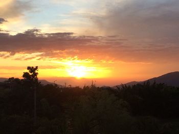 Scenic view of silhouette mountains against orange sky