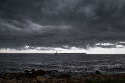 Scenic view of sea against storm clouds