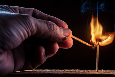 Midsection of person holding burning candle