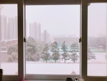 Buildings seen through window during winter