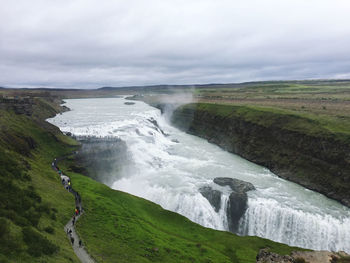 Scenic view of waterfall against sky