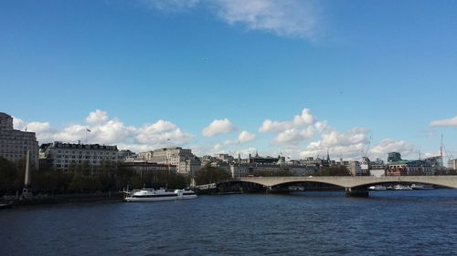 Bridge over river with cityscape in background