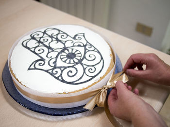 Close-up of woman decorating a cake