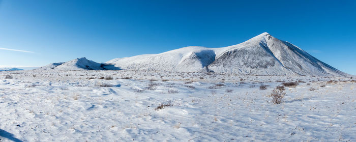 Scenic view of snowcapped mountains against clear blue sky