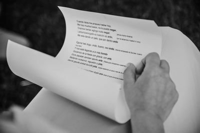 Midsection of person holding paper