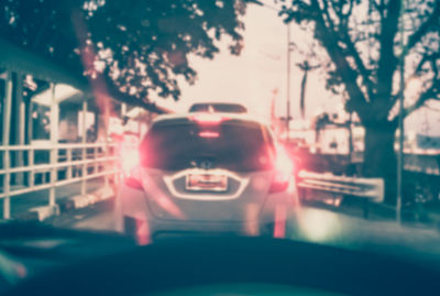 Cars in illuminated city seen through car windshield