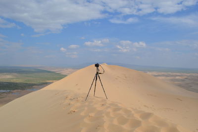 Scenic view of sand dune on beach against sky