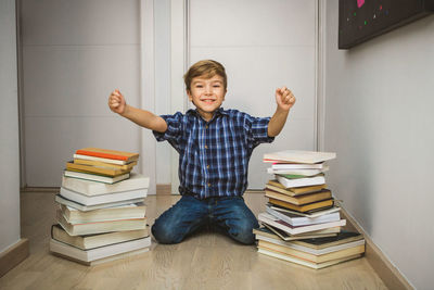 Portrait of happy boy with books at home