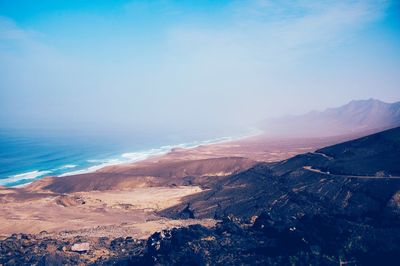 Scenic view of sea and mountains against sky