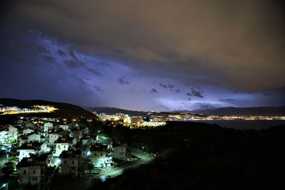 Illuminated cityscape against sky at night