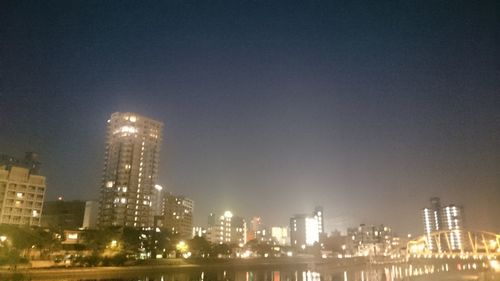 Illuminated cityscape against sky at night