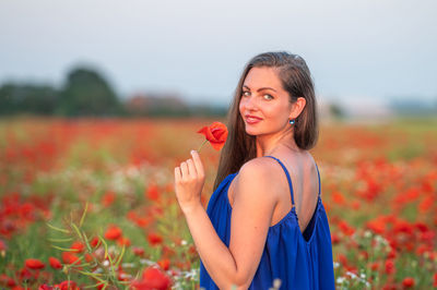 Portrait of young woman holding flowers