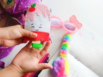 Cropped hand of child holding toy over table