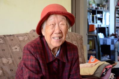 Happy senior woman sitting on sofa at home