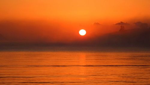 Scenic view of sea against romantic sky at sunset