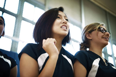 Low angle view of girls standing against windows in court