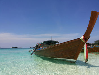 Boat moored on beach against sky