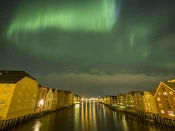 River amidst illuminated city against sky at night