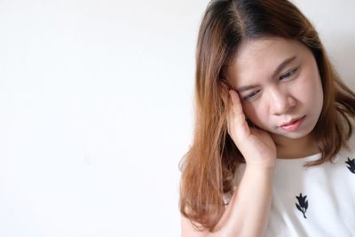 Close-up portrait of a teenage girl against white background