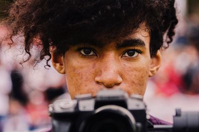 Close-up portrait of man with camera