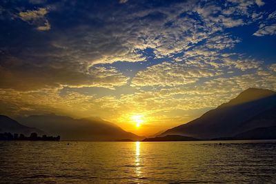 Scenic view of sea against dramatic sky during sunset