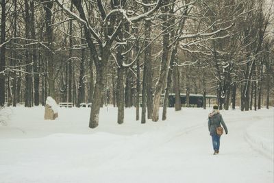 Woman walking on snow covered landscape