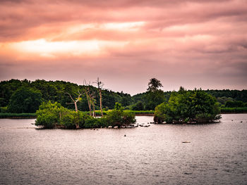 Scenic view of river against sky at sunset