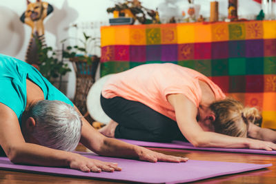 Mother and daughter practicing yoga at spa