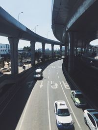 Cars on highway by bridge in city against sky