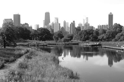 Scenic view of lake by buildings against clear sky