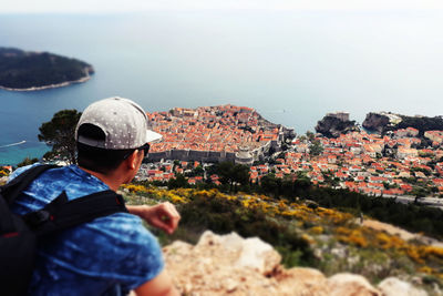 Man looking townscape against sea