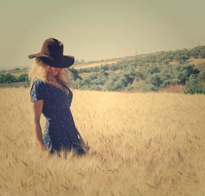 Side view of young woman standing on field