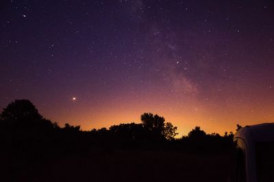 Silhouette trees against sky at night