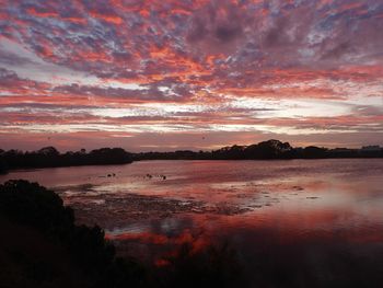 Scenic view of lake against romantic sky at sunset