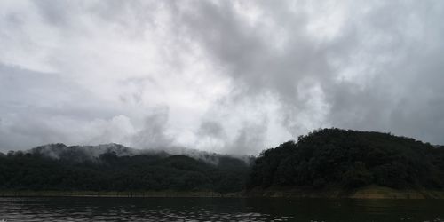 Scenic view of lake by mountain against sky