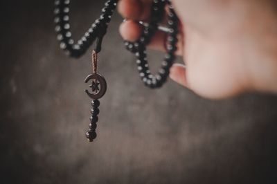 Close-up of human hand holding chain