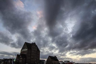 Buildings in city against cloudy sky