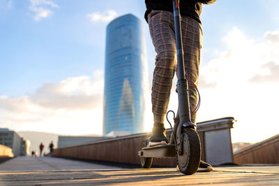 Low section of person with bicycle against sky