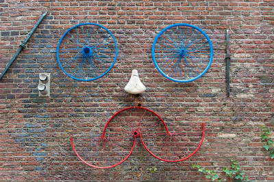 Art made from bicycle parts on brick wall