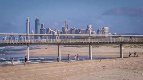 People on beach by sea against sky