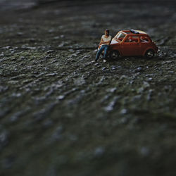 Close-up of toy car with figurine on floor