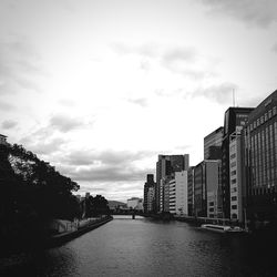 River amidst city against sky