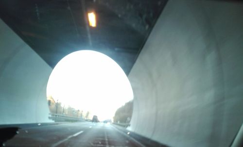 Illuminated tunnel seen through car windshield