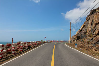 Road leading towards mountain against sky