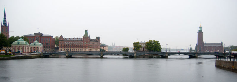 Bridge over river in city against clear sky